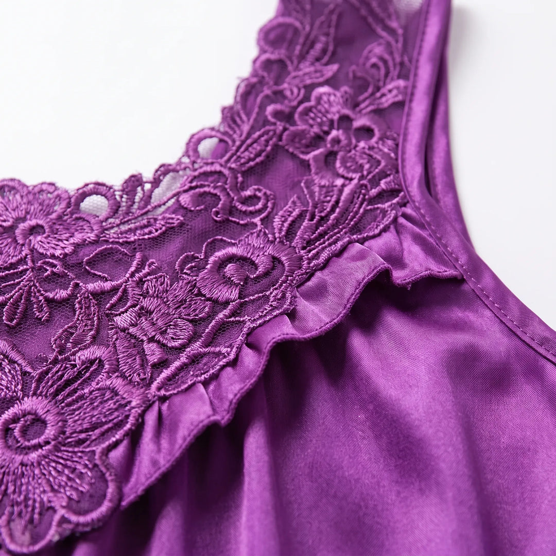 Close-up of the purple nightgown's embroidered floral lace neckline, ruffled satin edge and finished strap seam. 5