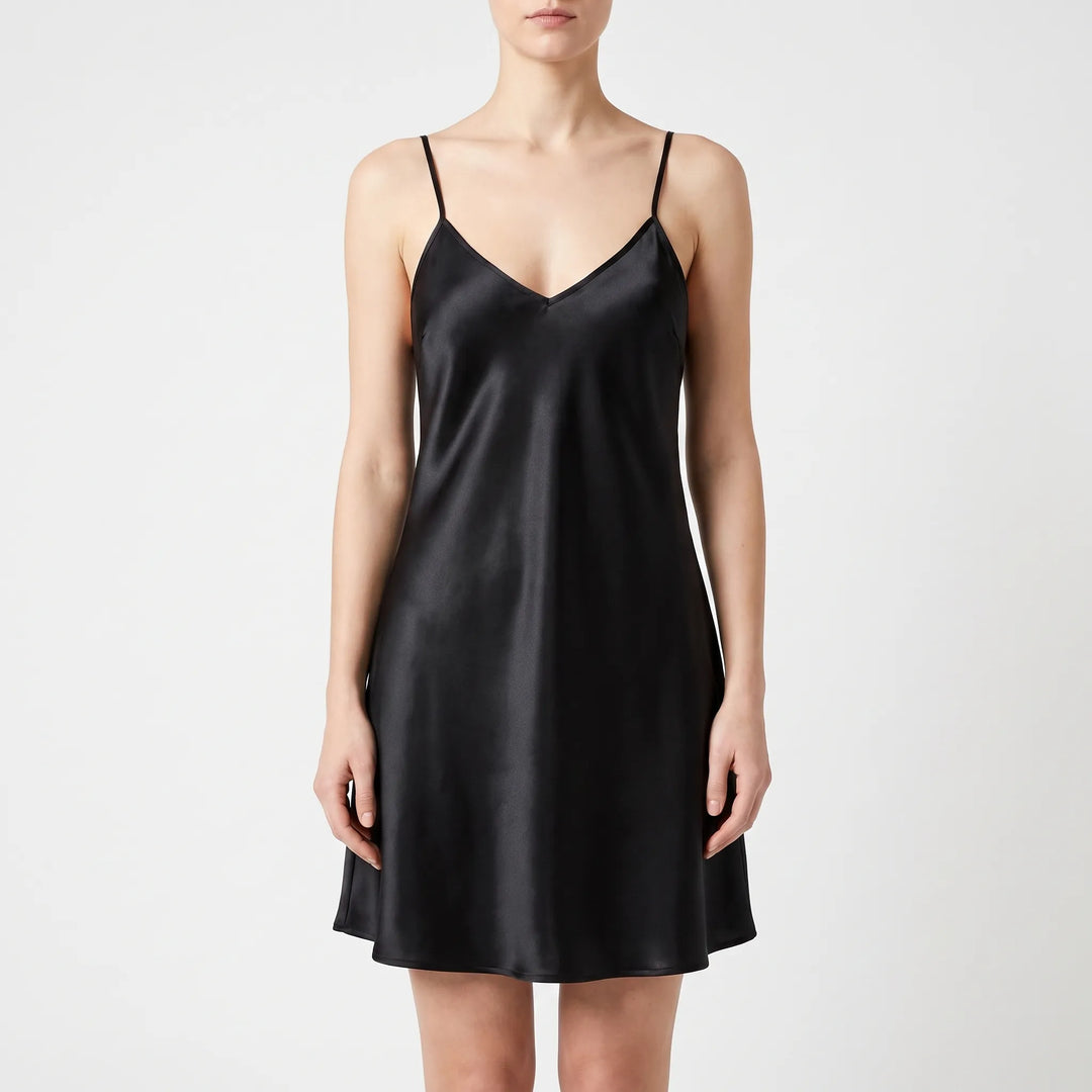 Model wearing the slip nightdress in glossy black satin, front view on a light gray background. 10