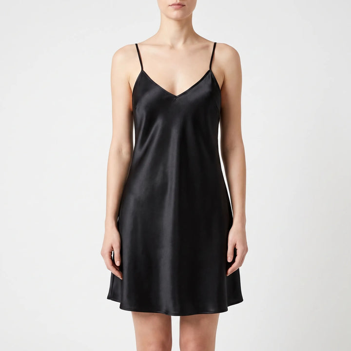 Model wearing the slip nightdress in glossy black satin, front view on a light gray background. 10