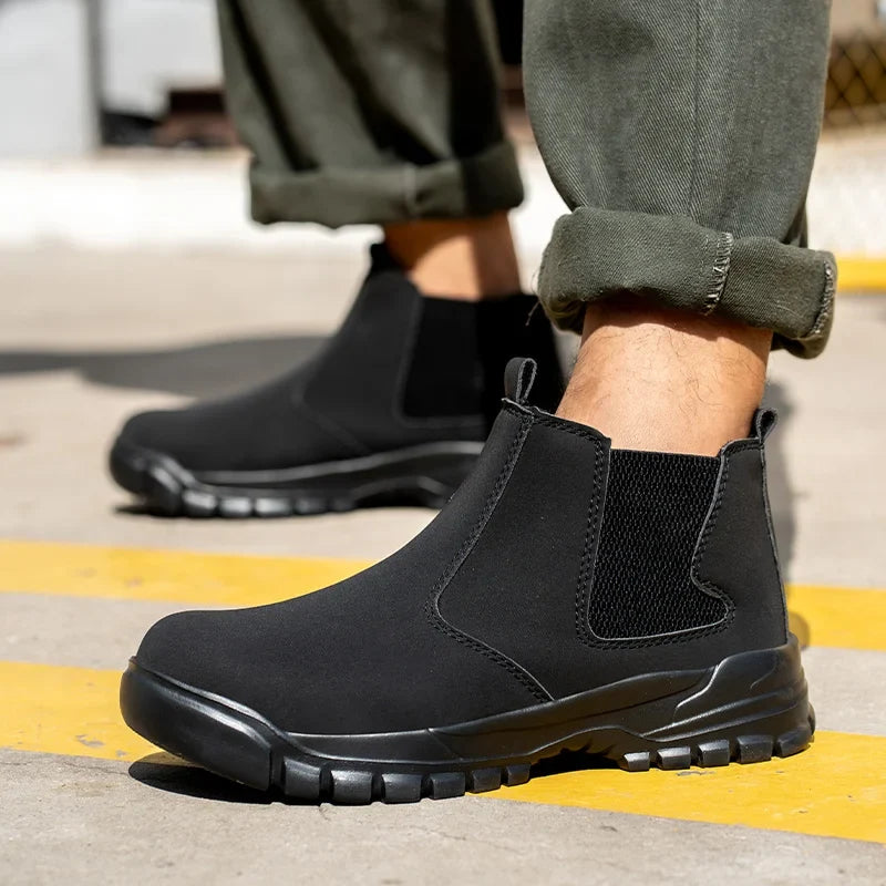 Model wearing black slip-on ankle boots with elastic side panels, standing on concrete with yellow painted lines 1