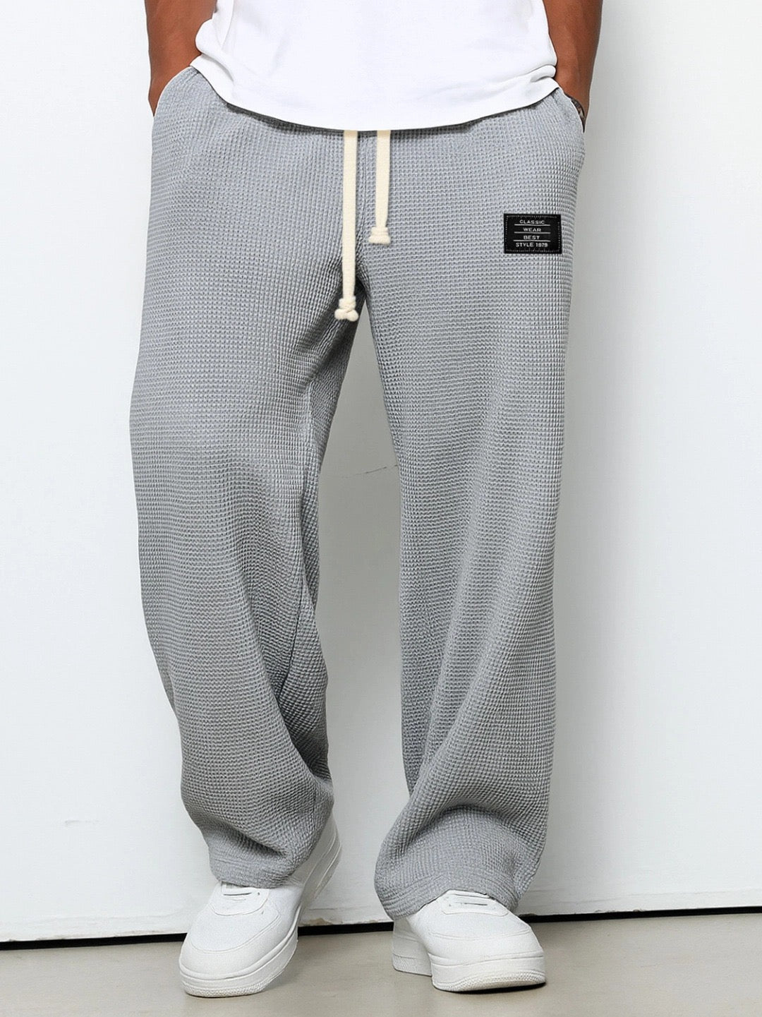 Front view on a model of the wide leg waffle knit pants in light gray 3