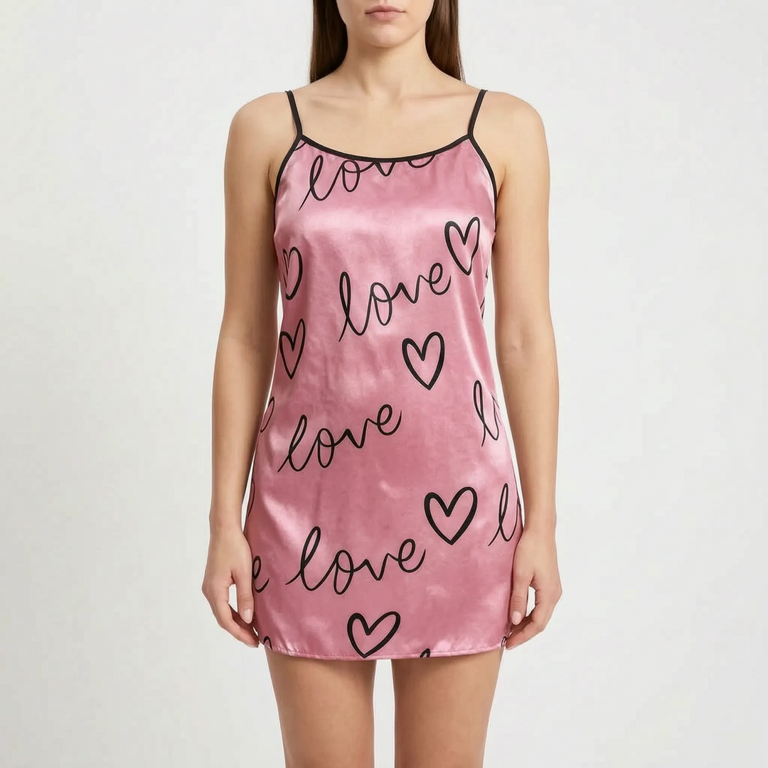 Front view on a model of the pink satin nightgown with black handwritten lettering and outlined hearts, finished with black trim. 8