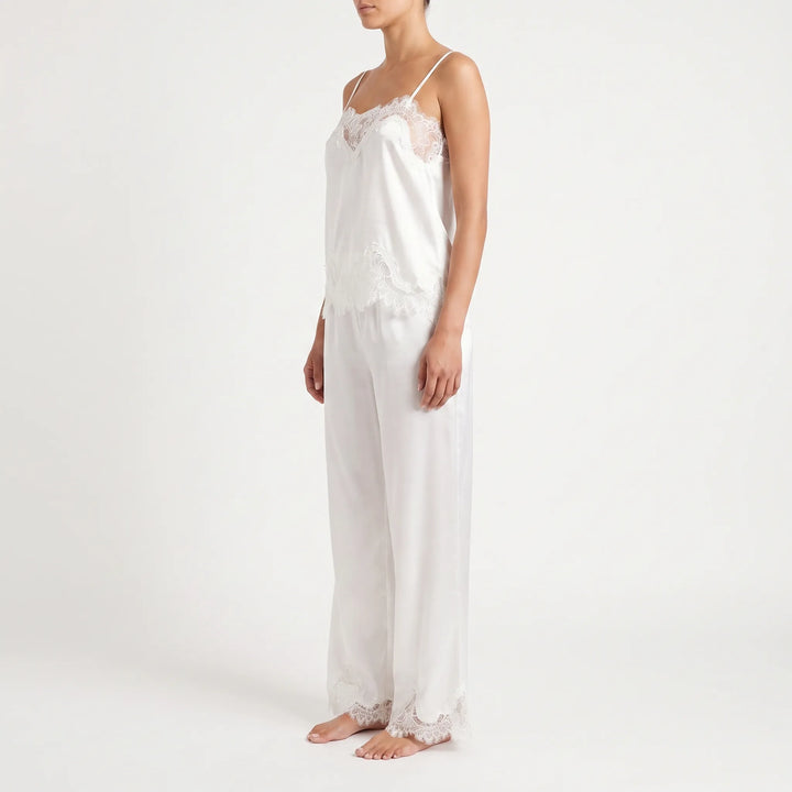 Side view of the white satin cami and wide-leg pants on a model, with lace at the cami hem and pant cuffs. 4