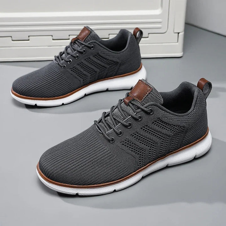 Dark gray lace-up sneakers with white soles and brown trim.