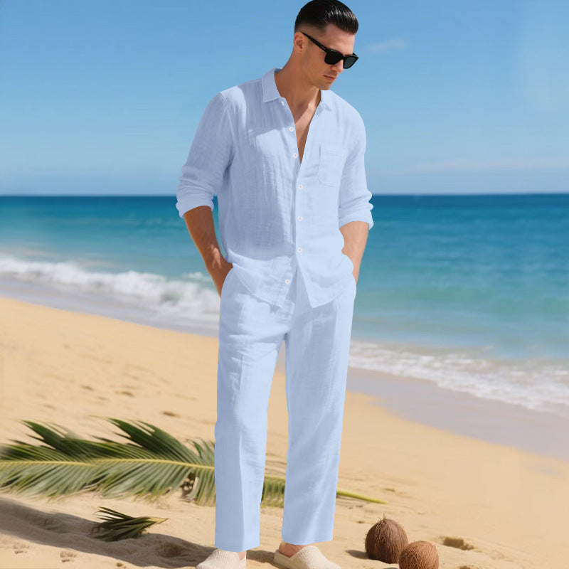 Men's linen shirt and pants set in pale sky blue on a beachside model, another view.