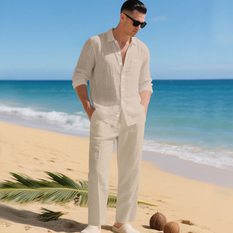 Men's linen shirt and pants set in soft beige on a model by the shore, another view.