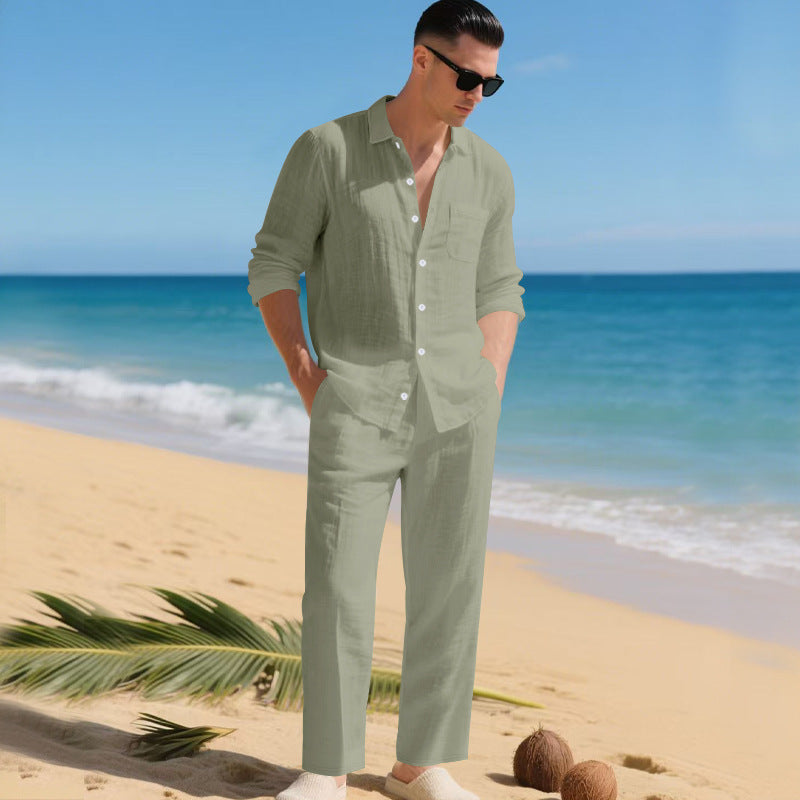 Men's linen shirt and pants set in sage green on a man on the sand, another view.