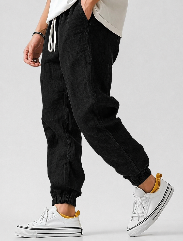 Black textured drawstring joggers with elastic cuffs, another view.