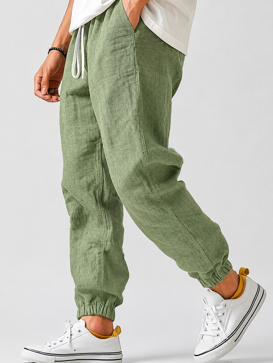 Sage green textured drawstring joggers with elastic ankle cuffs, another view.