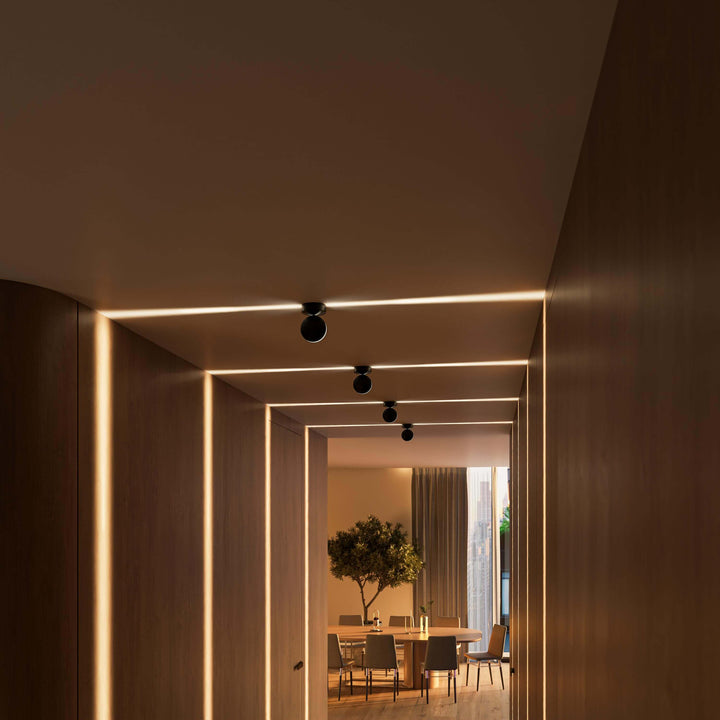 Black LED wall sconce another view showing warm horizontal beams across the ceiling and down the walls.