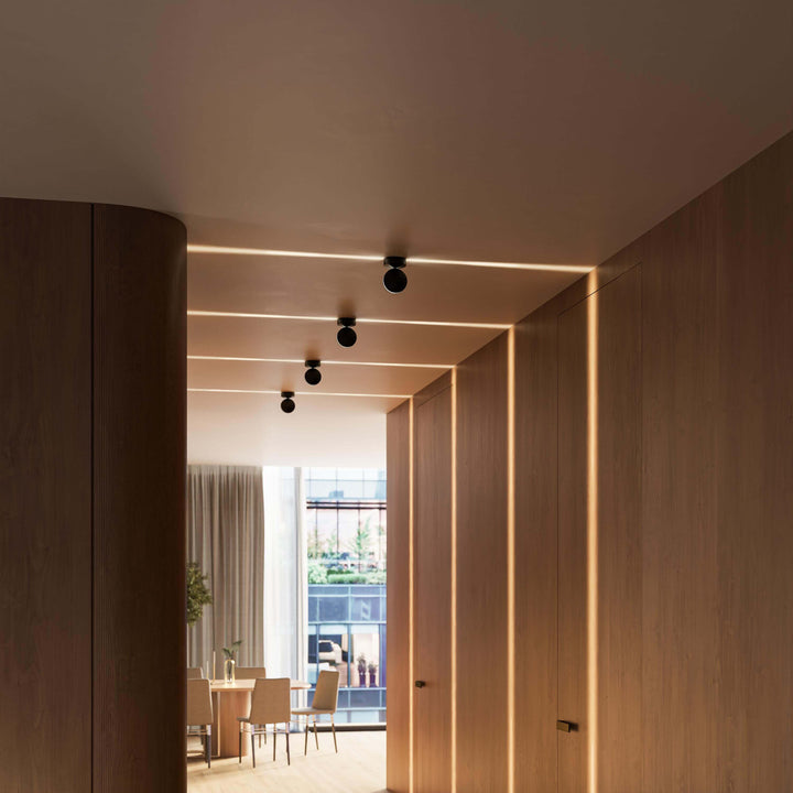 Four black LED wall lights in a wood-paneled passage, with light lines across the walls.