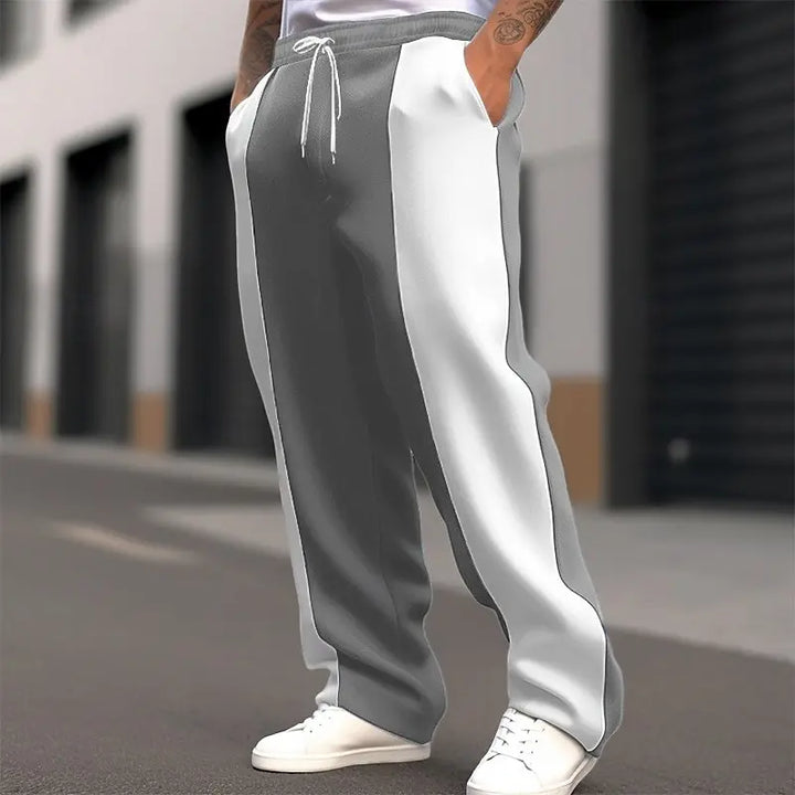 Model wearing gray and white color-block sweatpants with a drawstring waist, one hand in pocket, on a city street 4
