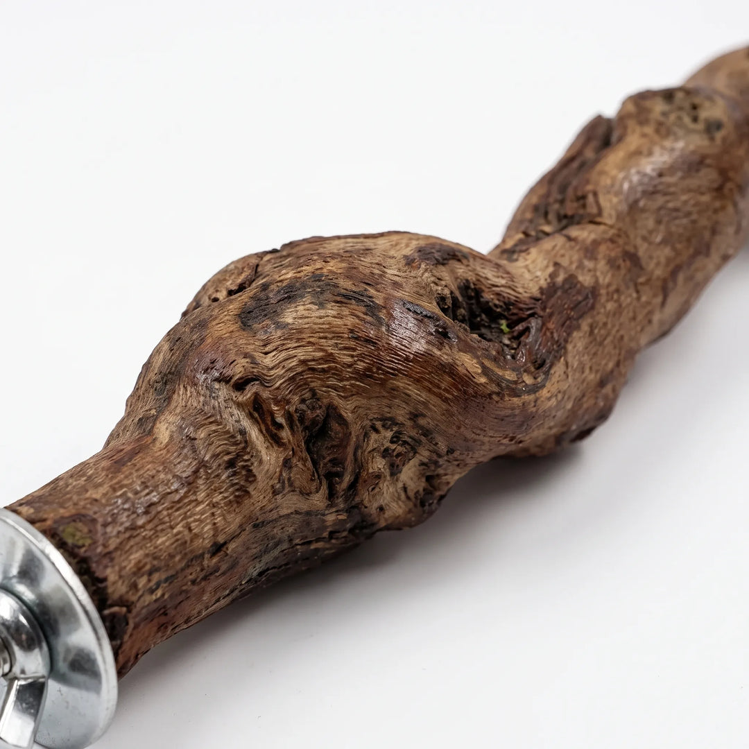 Close-up of the perch's rough, knotted wood grain and the metal washer and wing nut at its mounting end. 3