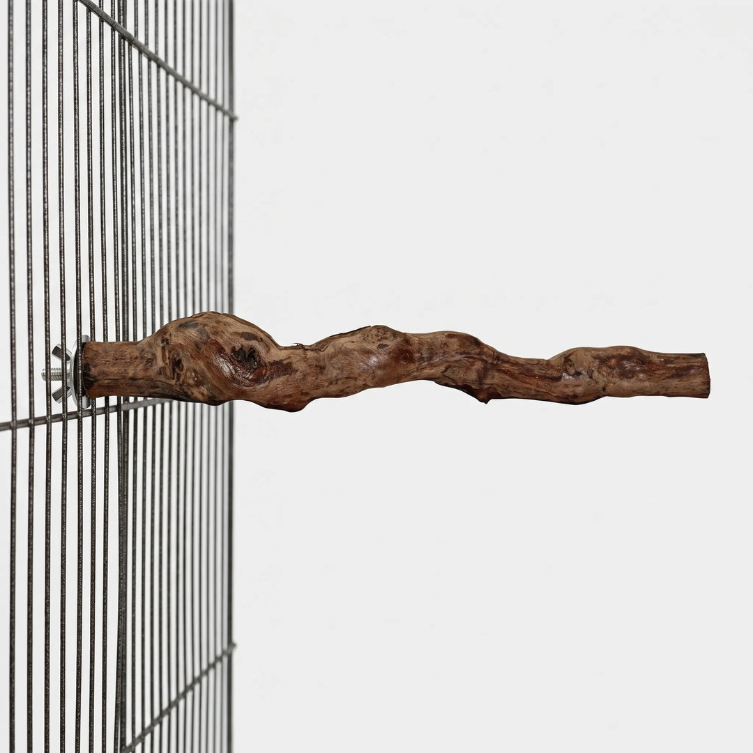 Side view of the knotty wooden perch attached to a dark wire cage panel with a wing nut. 4
