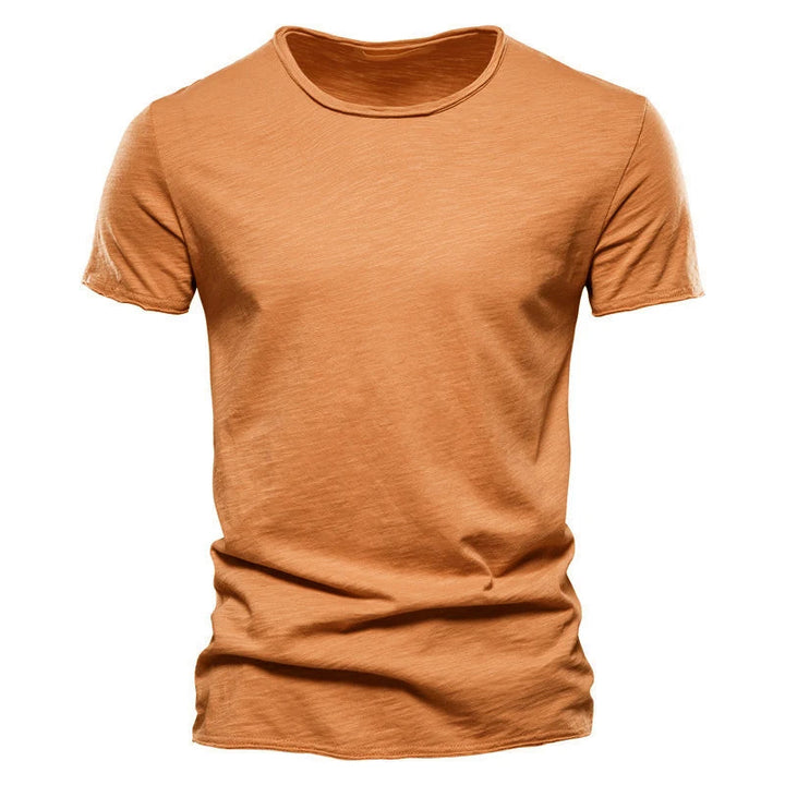 Burnt orange Men's T-Shirt showing slubby fabric texture and raw-edge collar, laid flat from the front.