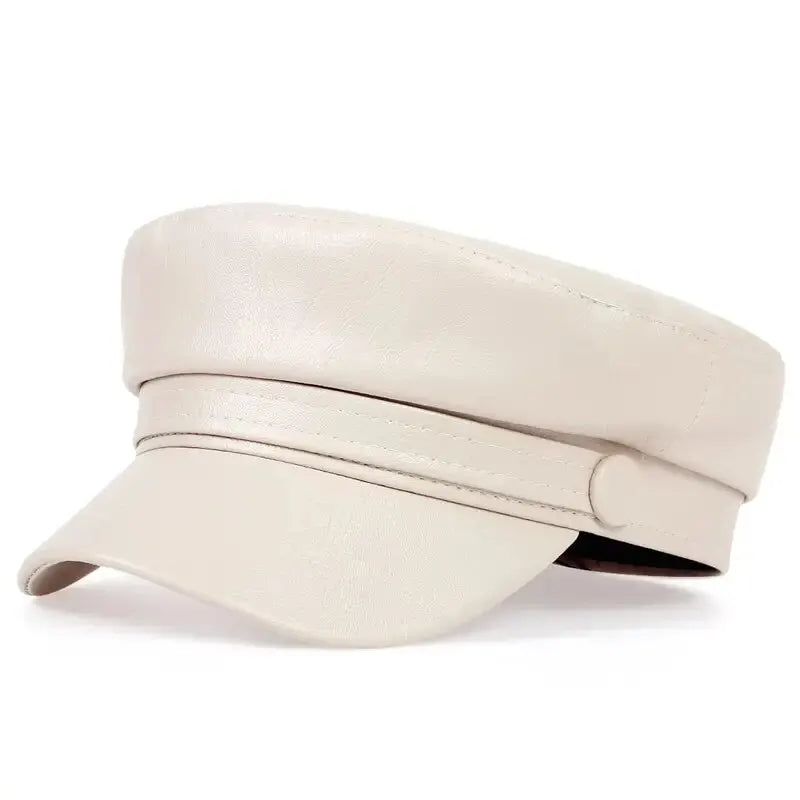 Cream leather-look flat cap with a button strap, shown at a three-quarter angle 17