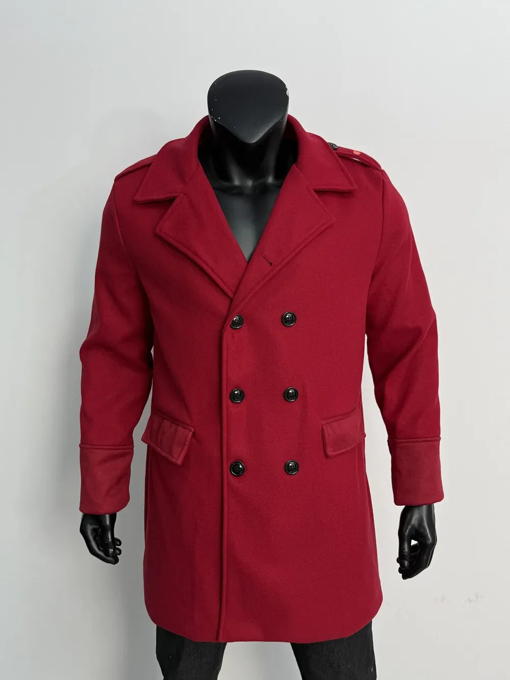 Burgundy red double-breasted coat on a black mannequin, front view with black buttons, flap pockets and epaulettes 7