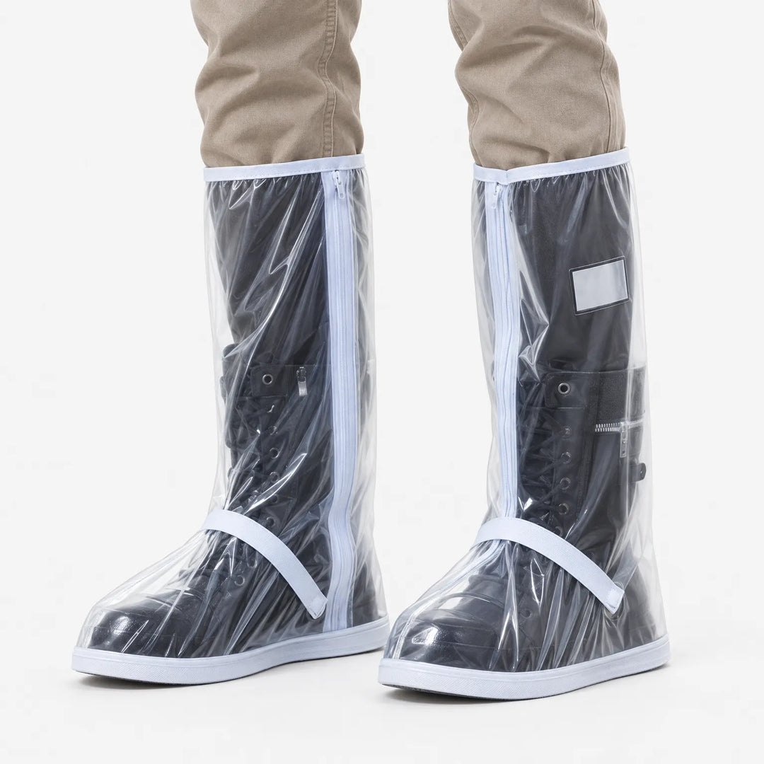 Front view of clear plastic tall shoe covers with white trim and zippers, worn over black lace-up boots with khaki pants. 2