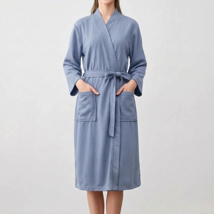 Front view of a model in the slate blue robe with hands in the two patch pockets and the belt tied at the waist. 6