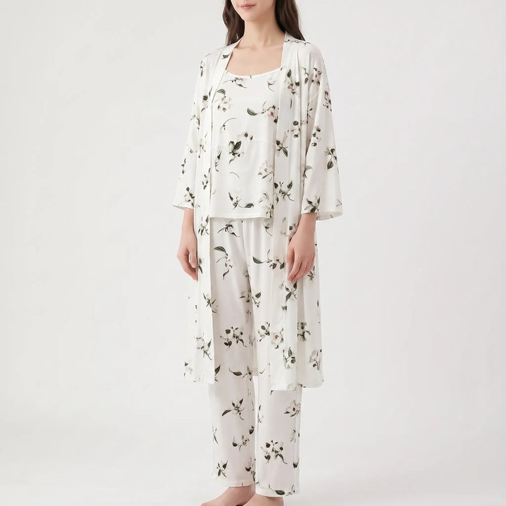 Angled view of the set in white with scattered dark green leaves and small flowers, worn by a model. 10