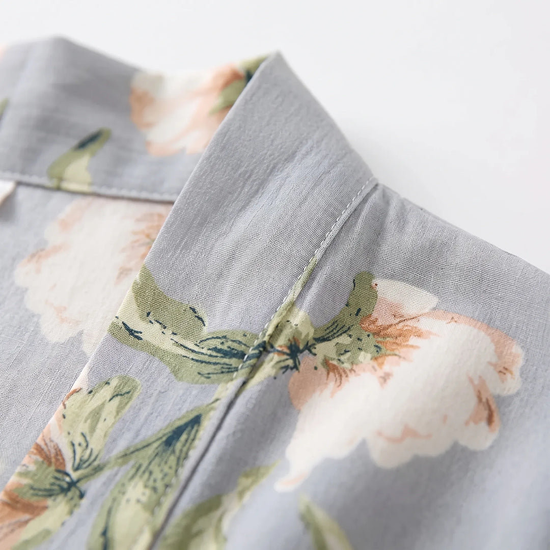 Close-up of the robe's collar and stitched seam on gray fabric printed with peach flowers and green leaves. 5