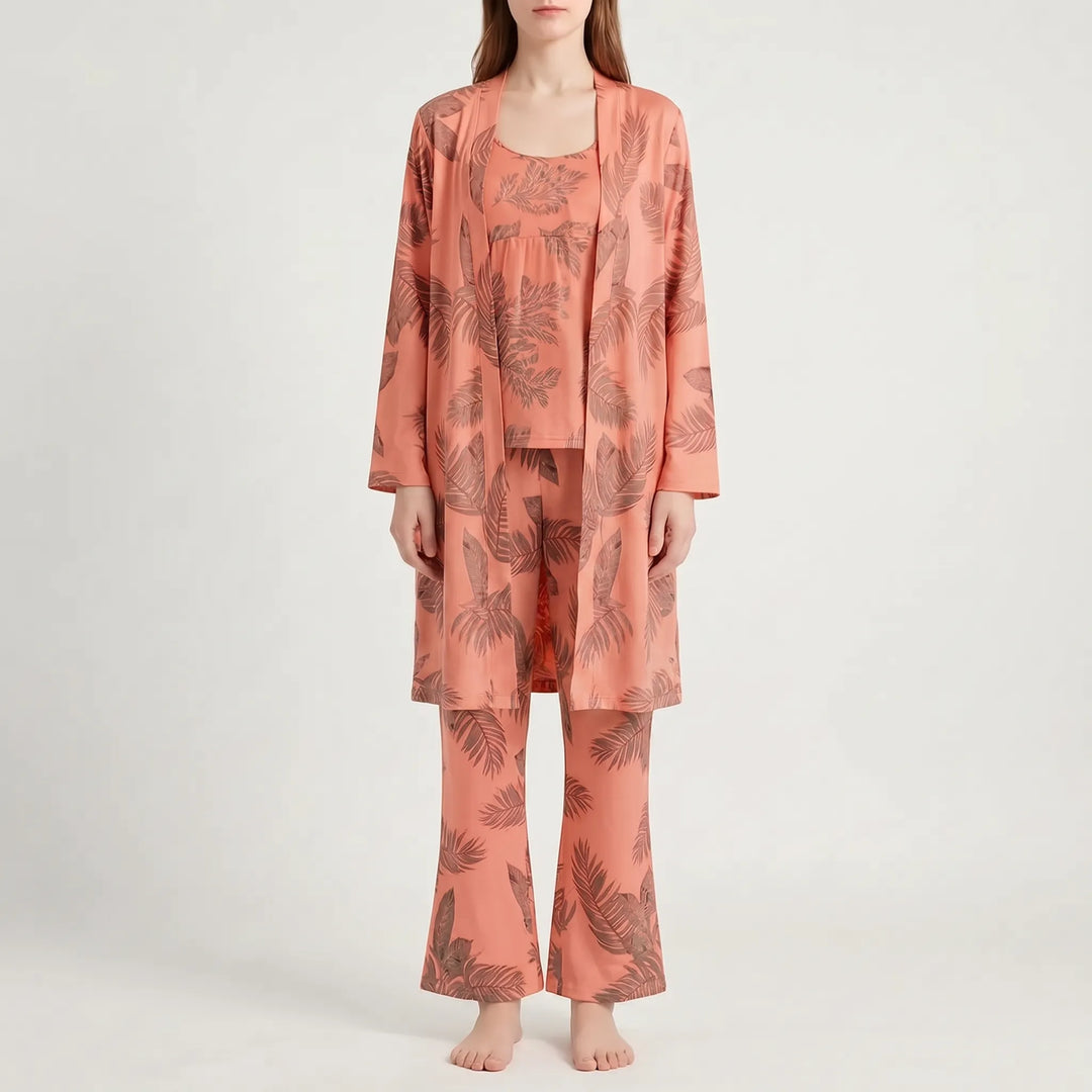 Front view of the set in coral orange with a brown leaf print, worn by a model with flared pants. 9