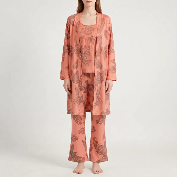 Front view of the set in coral orange with a brown leaf print, worn by a model with flared pants. 9