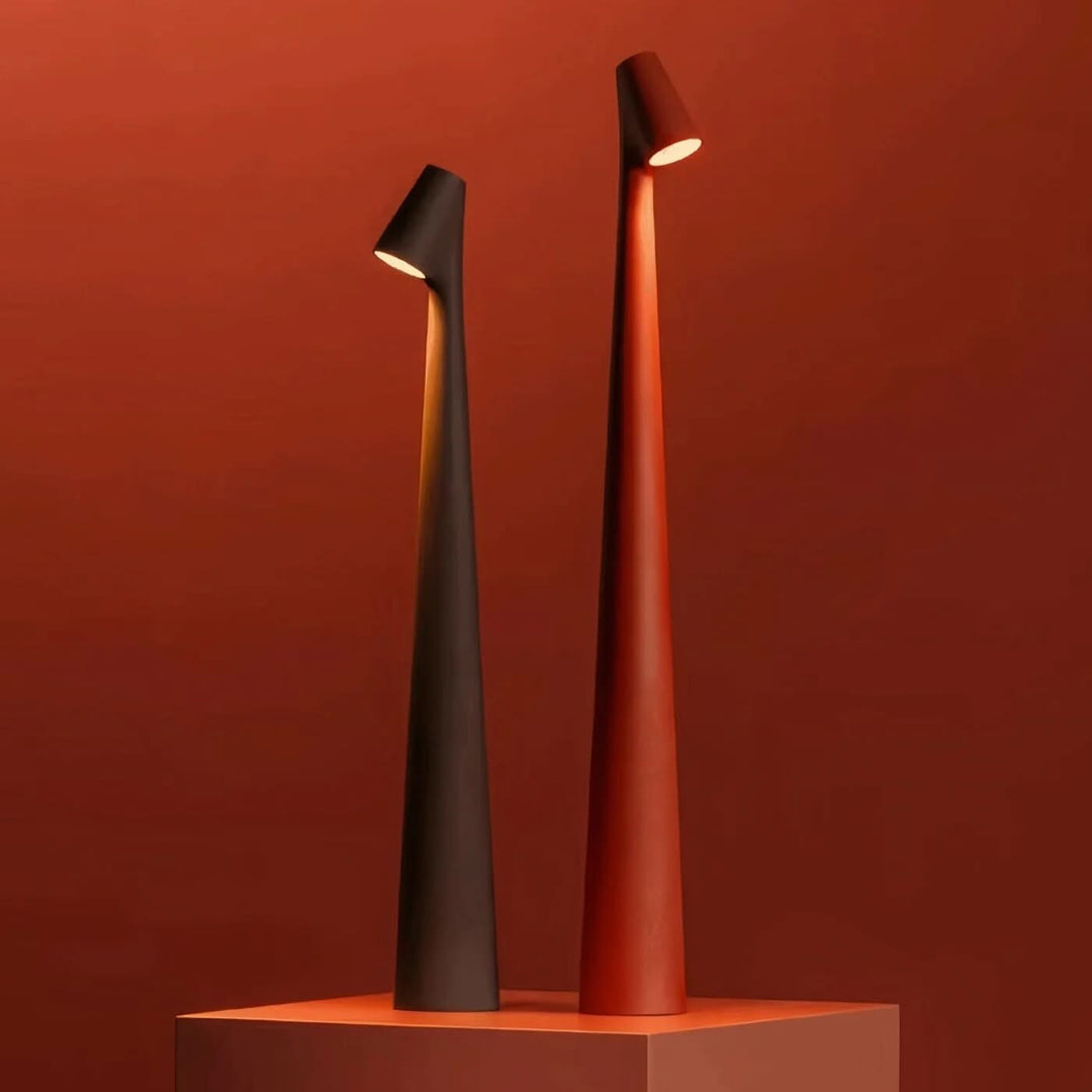 Two lit lamps, one dark brown and one terracotta red, on a red pedestal against a matching deep red wall. 17