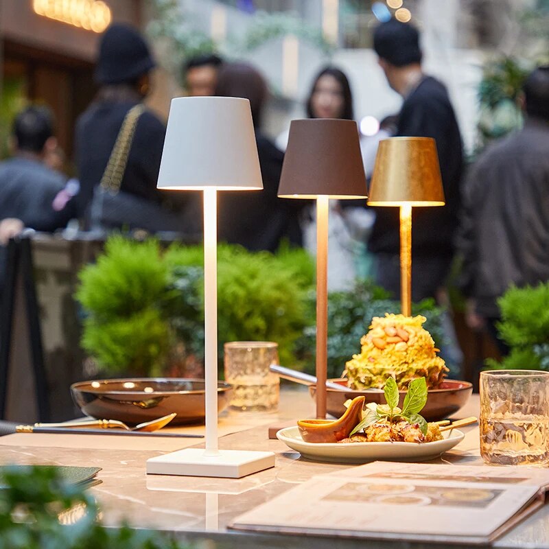 Another view of three lamps in white, brown and gold on a restaurant table.