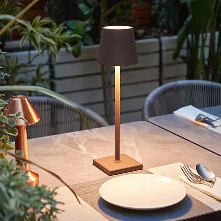 Another view of a copper-toned lamp on an outdoor dining table.