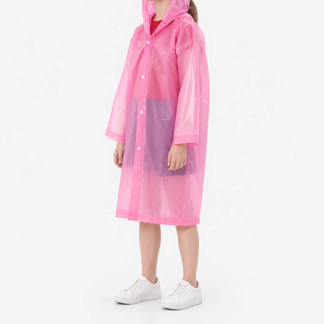 Side three-quarter view of a girl in the pink translucent hooded raincoat, snap front closed, with white sneakers. 5