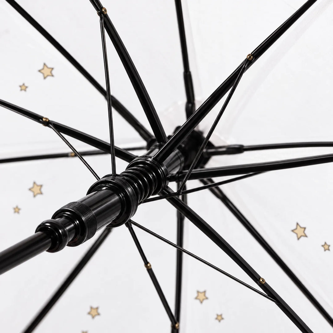 Close-up of the underside of the umbrella showing the black ribs, spring runner and shaft, with small gold stars on the canopy. 6