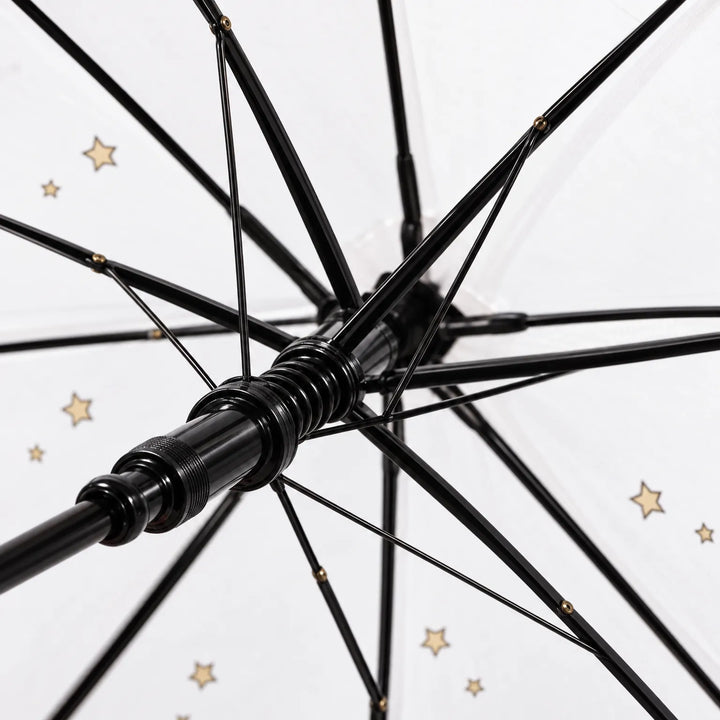 Close-up of the underside of the umbrella showing the black ribs, spring runner and shaft, with small gold stars on the canopy. 6