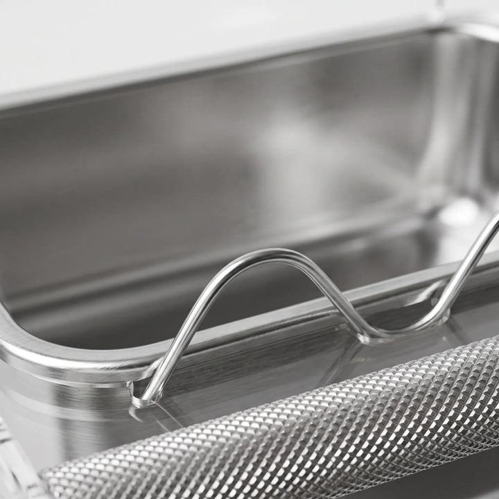 Close-up of the textured metal perch bar and the wavy clear divider in front of the stainless steel tray. 3