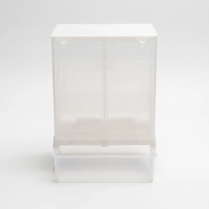 Front view of the empty clear plastic seed feeder with a white lid and a pull-out catch tray at the bottom. 1