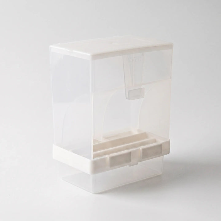 Angled view from the other side showing the hopper's curved interior, the white base with feeding slots, and the clear tray. 5