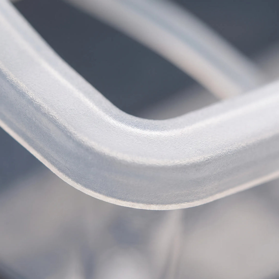 Extreme close-up of the frosted, slightly textured plastic rim and rounded corner of the feeder. 4