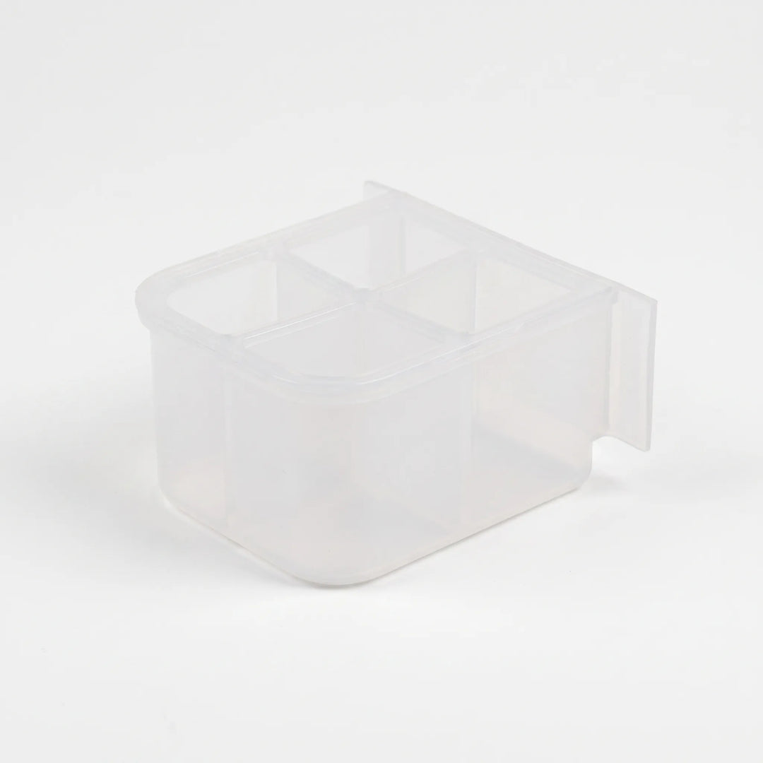 Empty small frosted-plastic feeder seen from above at an angle, showing four separate compartments and a flat back panel. 5