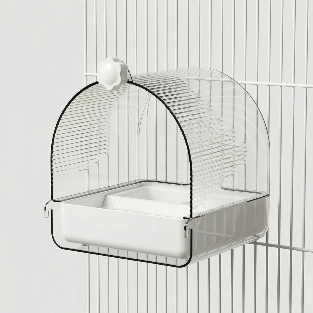 Side angle of the bath hanging on white cage bars, with the clear ribbed dome, white tray, and flower-shaped knob. 4
