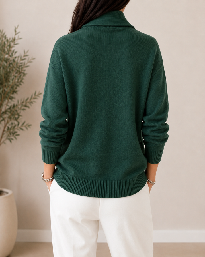 Back view of the dark green sweater showing the plain back, ribbed cuffs and hem, and collar.