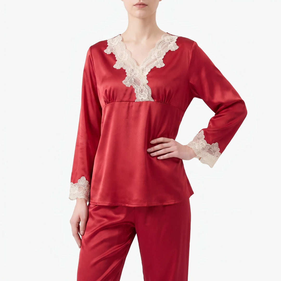Close front view of the red satin pajama top on a model, hand on hip, showing the lace V-neckline and cuffs. 2