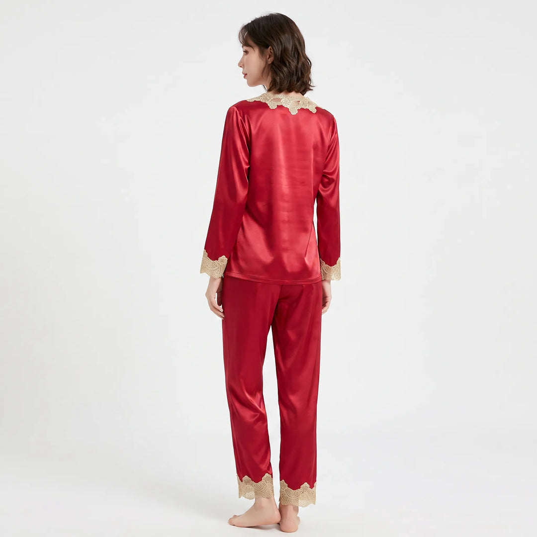 Back view of the red satin pajamas on a model, showing cream lace at the neckline, cuffs and pant hems. 3