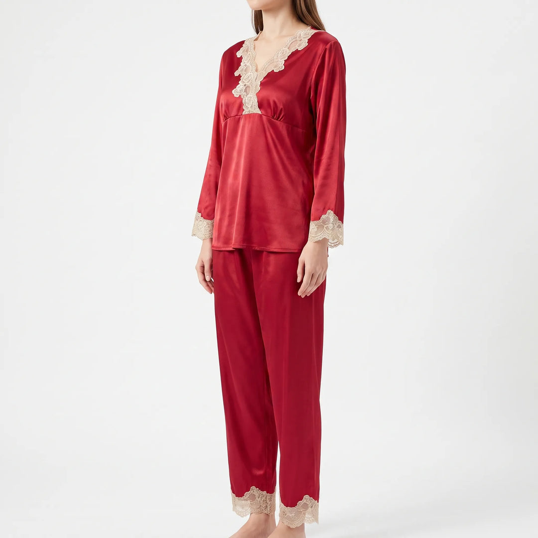 Three-quarter side view of a model in the red satin pajama set with lace V-neck, cuffs and ankle hems. 4