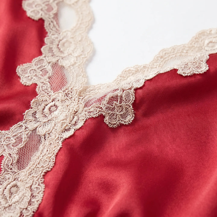 Close-up detail of the cream floral lace trim along the V-neckline on red satin fabric. 5