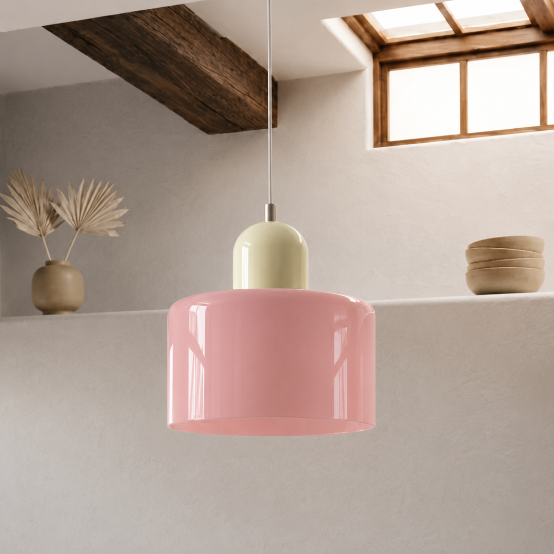 Pink glass drum shade with a pale yellow dome cap hangs from a white cord in a beamed room. 40