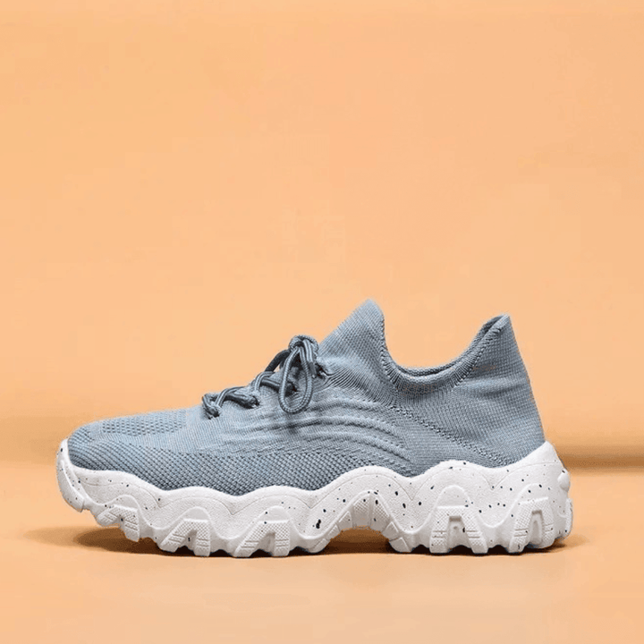 Another view of a light blue knit sneaker with matching laces and a chunky white speckled sole.