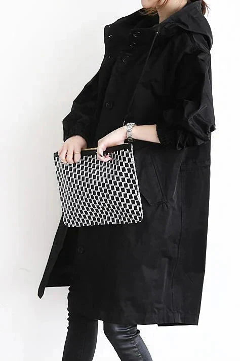 Black waterproof hooded trench coat detail showing the hood and sleeve cuffs
