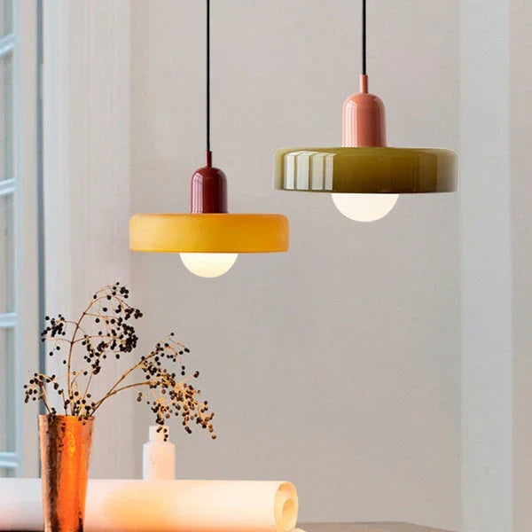 Two pendants side by side: an amber-yellow shade with a dark red cap and an olive shade with a pink cap. 26