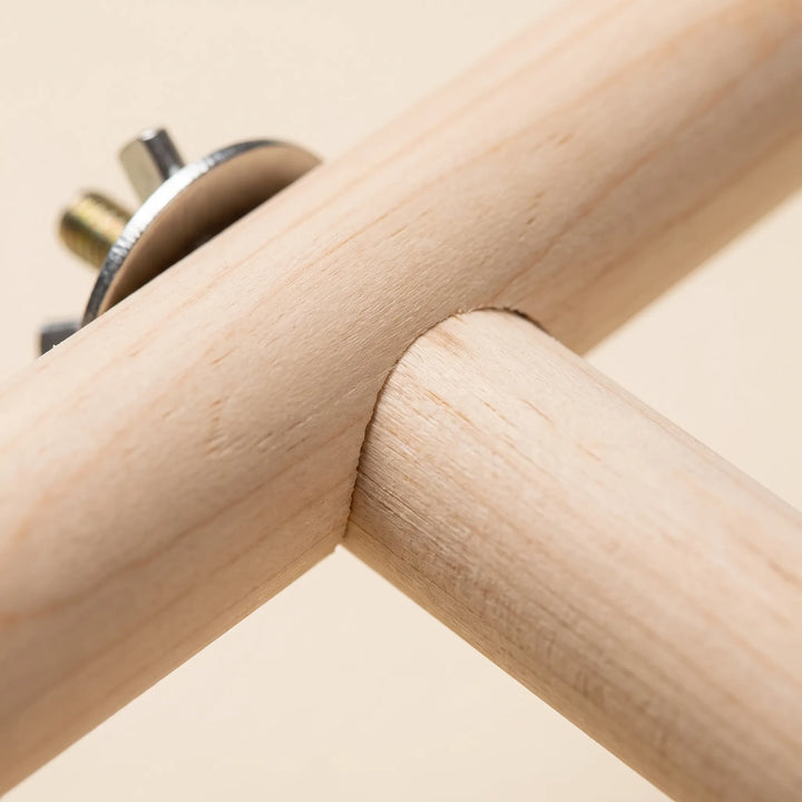 Close-up of the joint where two smooth wooden dowels meet, with a metal washer and threaded bolt visible at the end. 3