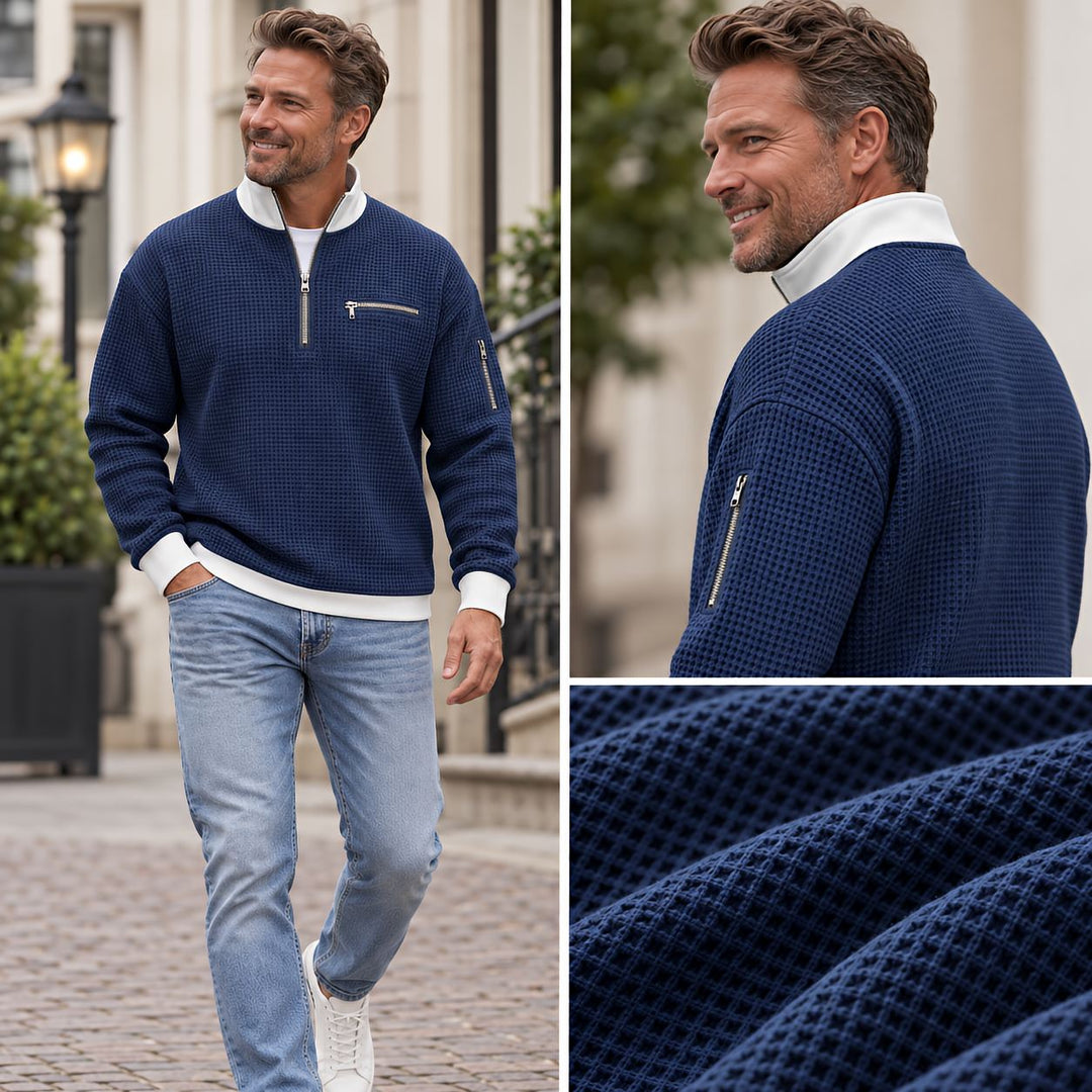Another view of a navy waffle knit sweater with a sleeve zip pocket and texture detail.